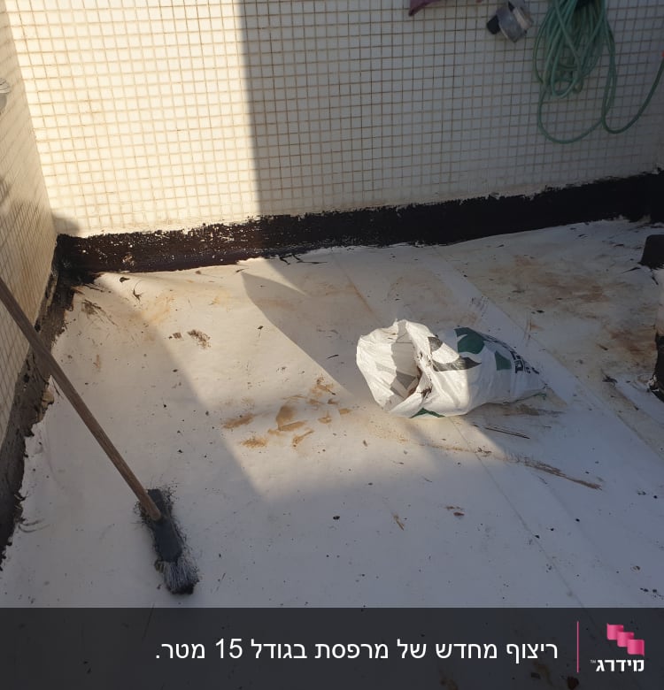 מטאטא, שקית וחומרי בנייה על רצפה לבנה